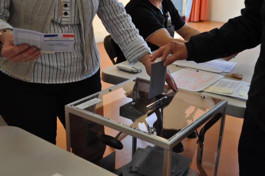 Vote élections, une personne dépose son bulletin dans l'urne