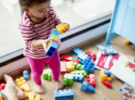 Petite fille qui joue avec des briques empilables