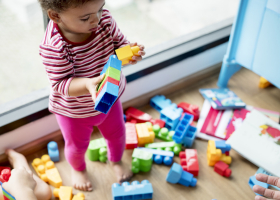 Petite fille qui joue avec des briques empilables